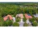 Aerial view showcases homes with private pools surrounded by lush greenery in a neighborhood at 5004 Waterkey Way, Tampa, FL 33647