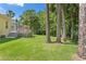 A large backyard featuring a deck with an umbrella, beautiful trees, and plenty of open space at 5004 Waterkey Way, Tampa, FL 33647
