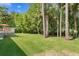 A well-manicured backyard with mature trees and a glimpse of the deck at 5004 Waterkey Way, Tampa, FL 33647