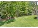 Spacious backyard featuring lush green grass, mature trees, and landscaping at 5004 Waterkey Way, Tampa, FL 33647