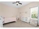 Cozy bedroom with a bed, a tent, a dresser, and an arm chair under a ceiling fan at 5004 Waterkey Way, Tampa, FL 33647