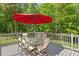 An outdoor deck with a dining set and a vibrant red umbrella at 5004 Waterkey Way, Tampa, FL 33647