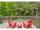 A cozy outdoor deck featuring a pair of red Adirondack chairs and lush landscaping at 5004 Waterkey Way, Tampa, FL 33647
