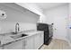 Laundry room with granite counters, modern cabinets, and new washer and dryer units at 5004 Waterkey Way, Tampa, FL 33647