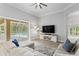 Inviting living room with large sliding glass doors to the pool, a plush sectional, and a mounted television at 5004 Waterkey Way, Tampa, FL 33647
