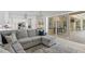 Open concept living room with kitchen, access to outdoor living space, and a plush sectional sofa at 5004 Waterkey Way, Tampa, FL 33647