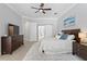 Spacious bedroom features an ensuite bathroom, ceiling fan, and access to pool at 5004 Waterkey Way, Tampa, FL 33647