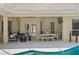 A covered patio featuring a lounge area, dining table, ceiling fan, and poolside views at 5004 Waterkey Way, Tampa, FL 33647