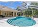 A luxurious pool with a screened lanai, outdoor dining area, and well-maintained patio at 5004 Waterkey Way, Tampa, FL 33647