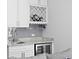 Stylish wet bar featuring white cabinetry, granite countertops, and a wine refrigerator at 5004 Waterkey Way, Tampa, FL 33647