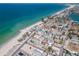 Amazing aerial view of a beach community with colorful houses, a white sand beach, and bright blue water at 515 77Th Ave, St Pete Beach, FL 33706