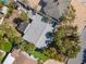 Aerial view of a home with a gray roof, surrounded by lush greenery, palm trees, and a backyard pool at 515 77Th Ave, St Pete Beach, FL 33706