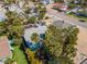An aerial shot of a bright blue home nestled among palm trees, featuring a backyard pool and a peaceful residential street at 515 77Th Ave, St Pete Beach, FL 33706