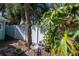 This backyard features green leafy plants, a small table, and a privacy fence at 515 77Th Ave, St Pete Beach, FL 33706