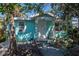 Charming aqua home featuring a quaint front porch with decorative metal supports at 515 77Th Ave, St Pete Beach, FL 33706