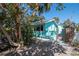 Sideyard view of an aqua home featuring an outdoor storage unit and fence at 515 77Th Ave, St Pete Beach, FL 33706