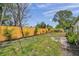 View of the backyard, featuring a manicured lawn, garden beds, and a newly installed wooden fence for added privacy at 5833 Dartmouth N Ave, St Petersburg, FL 33710