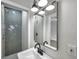 Stylish bathroom features gray herringbone tile in the shower, updated vanity, fixtures and lighting, all beautifully designed at 5833 Dartmouth N Ave, St Petersburg, FL 33710