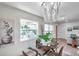 The dining room showcases a glass table, chandelier, and natural light at 5833 Dartmouth N Ave, St Petersburg, FL 33710