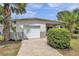 View of house with garage, beautiful exterior and landscaping at 5833 Dartmouth N Ave, St Petersburg, FL 33710