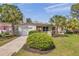 Inviting home exterior features a manicured lawn, mature palm trees, and a neatly paved driveway for enhanced curb appeal at 5833 Dartmouth N Ave, St Petersburg, FL 33710