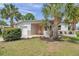 Charming home featuring mature landscaping with palm trees and a cozy front porch at 5833 Dartmouth N Ave, St Petersburg, FL 33710