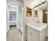 Bright bathroom features a white vanity, custom shelving, and leads to the main bedroom at 5849 Park N St # 308, St Petersburg, FL 33709