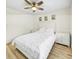 Well-lit bedroom with laminated floor, ceiling fan, and matching nightstands at 5849 Park N St # 308, St Petersburg, FL 33709