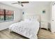 Bright bedroom with laminated floor, ceiling fan, and coastal-themed wall art at 5849 Park N St # 308, St Petersburg, FL 33709