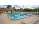 Community swimming pool and surrounding grounds featuring lounge chairs and a white fence at 5849 Park N St # 308, St Petersburg, FL 33709
