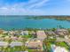 Stunning aerial view of waterfront homes along the tranquil bay with blue skies and a distant city skyline at 601 Boca Ciega Isle Dr, St Pete Beach, FL 33706