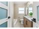 Bathroom featuring stone tile and a wood vanity with and sinks, and tub with shower at 601 Boca Ciega Isle Dr, St Pete Beach, FL 33706