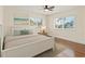 Bright bedroom featuring wood floors, a ceiling fan, and windows with neighborhood views at 601 Boca Ciega Isle Dr, St Pete Beach, FL 33706