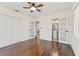 Bedroom with hardwood floors, ceiling fan, and modern doors leading to the ensuite bath at 601 Boca Ciega Isle Dr, St Pete Beach, FL 33706