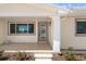 Charming front porch featuring a decorative glass door, ample windows, and tasteful landscaping at 601 Boca Ciega Isle Dr, St Pete Beach, FL 33706