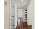 Hallway with hardwood floors, neutral walls, and white doors with black hardware at 601 Boca Ciega Isle Dr, St Pete Beach, FL 33706