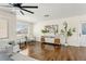 Well-lit living room featuring hardwood floors, two chairs, and an open layout to a dining space at 601 Boca Ciega Isle Dr, St Pete Beach, FL 33706