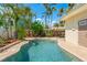 In-ground pool surrounded by brick and tropical landscaping and a partial view of the home at 601 Boca Ciega Isle Dr, St Pete Beach, FL 33706