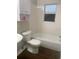 Cozy bathroom with tub, toilet, vanity, and a built-in shelf for storage at 6200 N 44Th St, Tampa, FL 33610