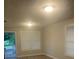 Well-lit living room with two windows, neutral walls, and a rear entrance door at 6200 N 44Th St, Tampa, FL 33610