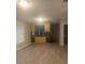 Living area featuring open bar to kitchen with wood-look floors and natural light at 6200 N 44Th St, Tampa, FL 33610