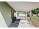 Carport with view of driveway, garage, yard and plants at 6544 S West Shore Cir, Tampa, FL 33616