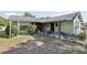 Charming exterior featuring a green house with a dark roof and front yard with plants at 6544 S West Shore Cir, Tampa, FL 33616