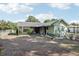 Charming exterior featuring a green house with a dark roof and front yard with plants at 6544 S West Shore Cir, Tampa, FL 33616