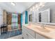 Bathroom featuring a double sink vanity and a shower-over-tub with blue accents at 7110 N Rome Ave, Tampa, FL 33604