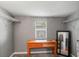 Bedroom with grey walls, beige carpet, and a wood desk in front of a window at 7110 N Rome Ave, Tampa, FL 33604