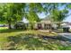 Single-story home with a covered parking area, featuring a well-maintained lawn and traditional design at 7110 N Rome Ave, Tampa, FL 33604