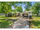 Charming single-story home with mature trees, well-maintained lawn, and a convenient carport at 7110 N Rome Ave, Tampa, FL 33604