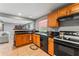 Functional kitchen featuring wood cabinets, black countertops, and essential appliances at 7110 N Rome Ave, Tampa, FL 33604