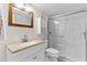 Bright bathroom with granite countertop sink, wood framed mirror, cabinet and enclosed shower at 7430 Sunshine Skyway S Ln # 402, St Petersburg, FL 33711